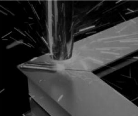 Close-up of an aluminum frame corner being seam-welded, sparks around the weld head